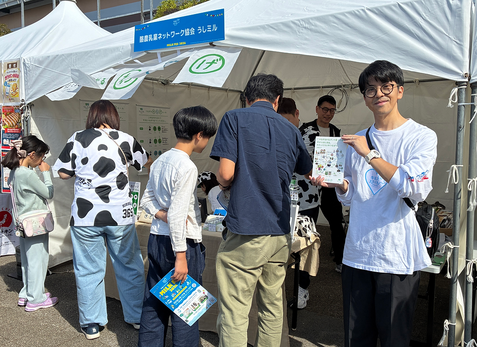 新企画「つながるわなげ」の説明資料を手に、ブース前に立つNPO法人うしミルの高砂理事長(右)