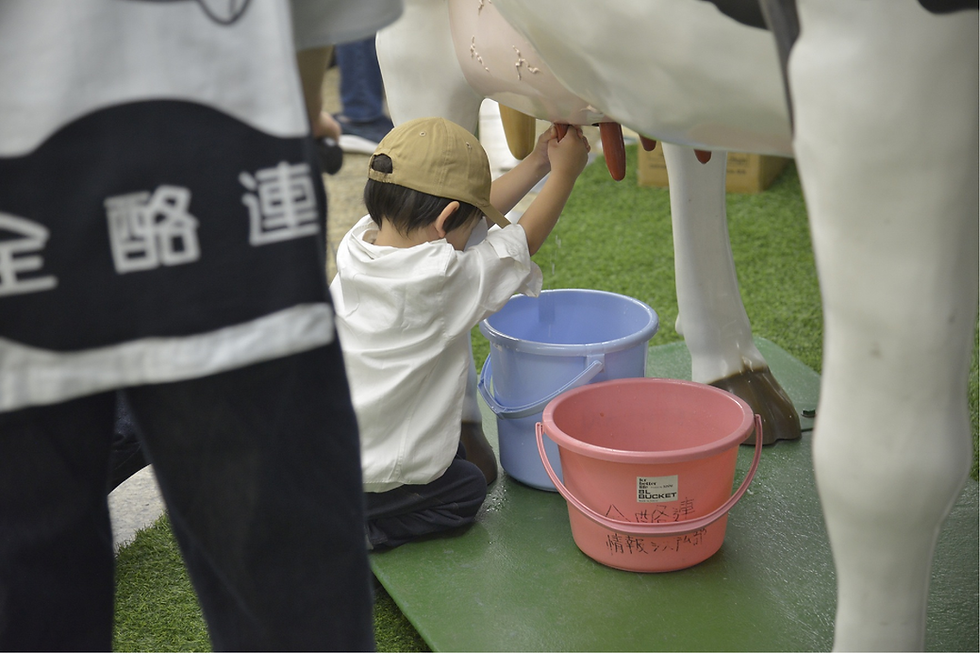 模擬牛による搾乳体験を楽しむ子ども
