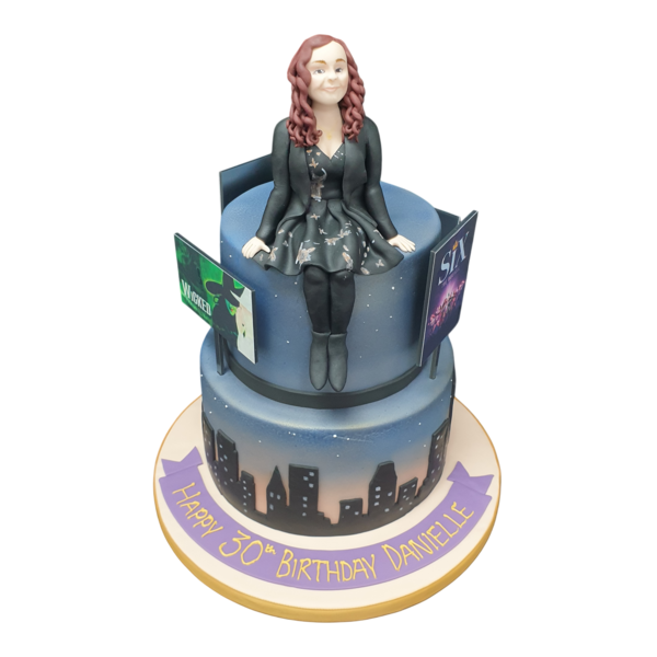 Beautifully decorated cake inspired by famous musicals on the West End, featuring iconic elements from beloved shows.