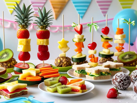 Mesa de festa infantil com comidas saudáveis e coloridas como espetadas de fruta, muffins de legumes e sanduíches divertidas, decorada com balões pastel ao fundo.
