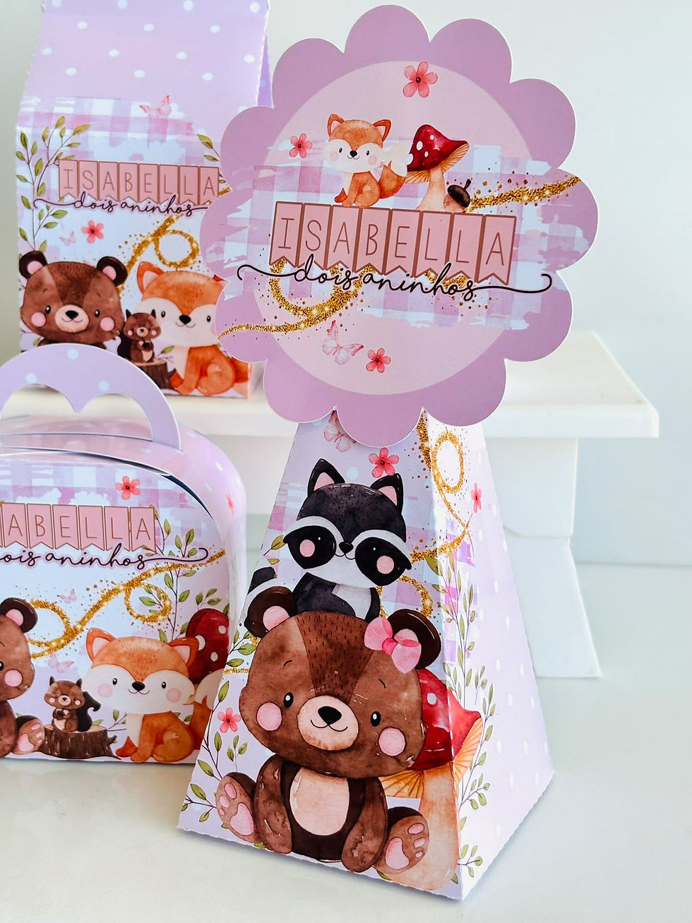 Miniatura: Quatro caixas Bosque Encantado em rosa e lilás, personalizadas com nome, com ursos, raposas, guaxinins e coelho.