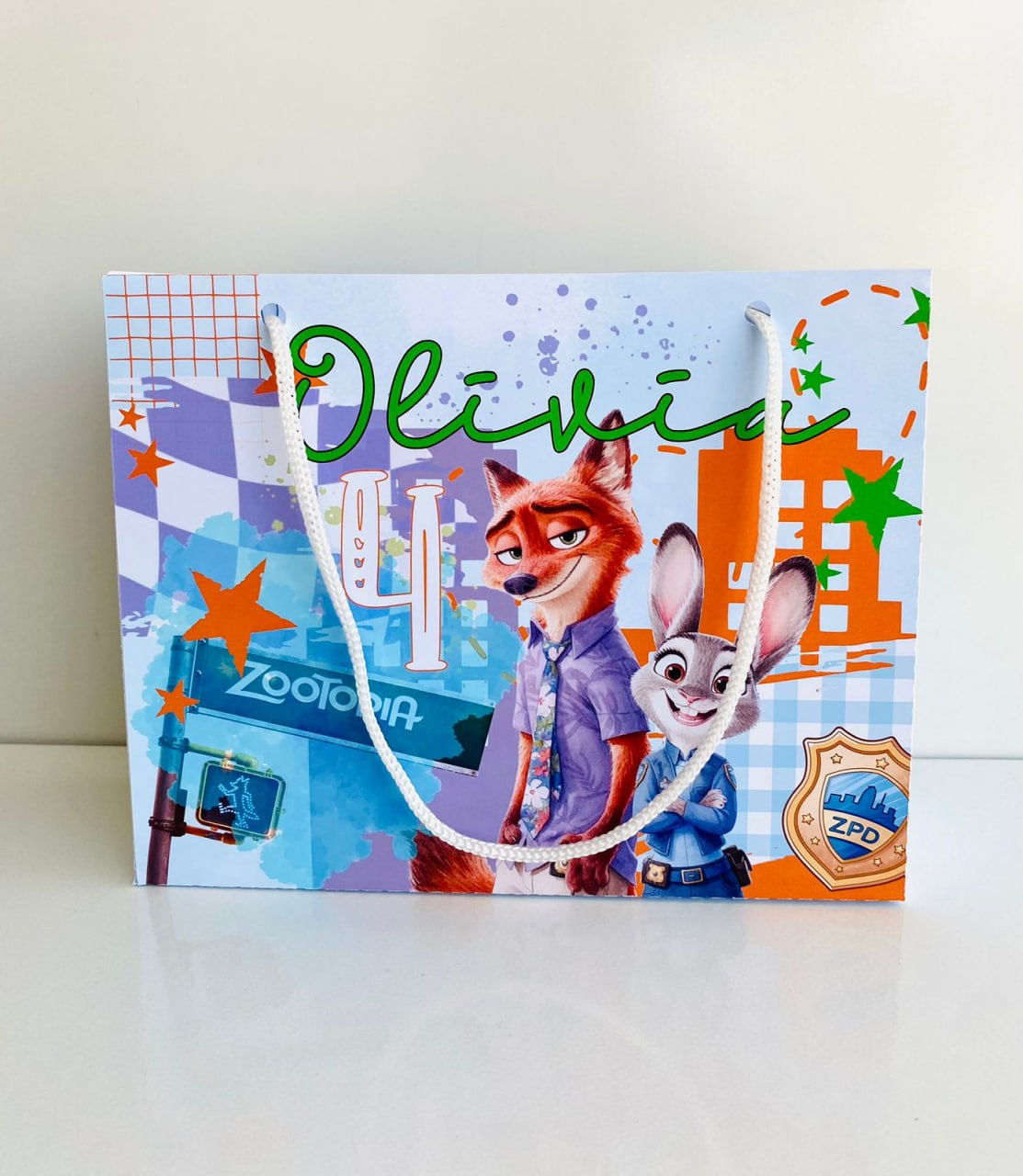 Sacolinha personalizada Zootrópolis com Judy Hopps, Nick Wilde, cenário urbano, nome e idade da criança.