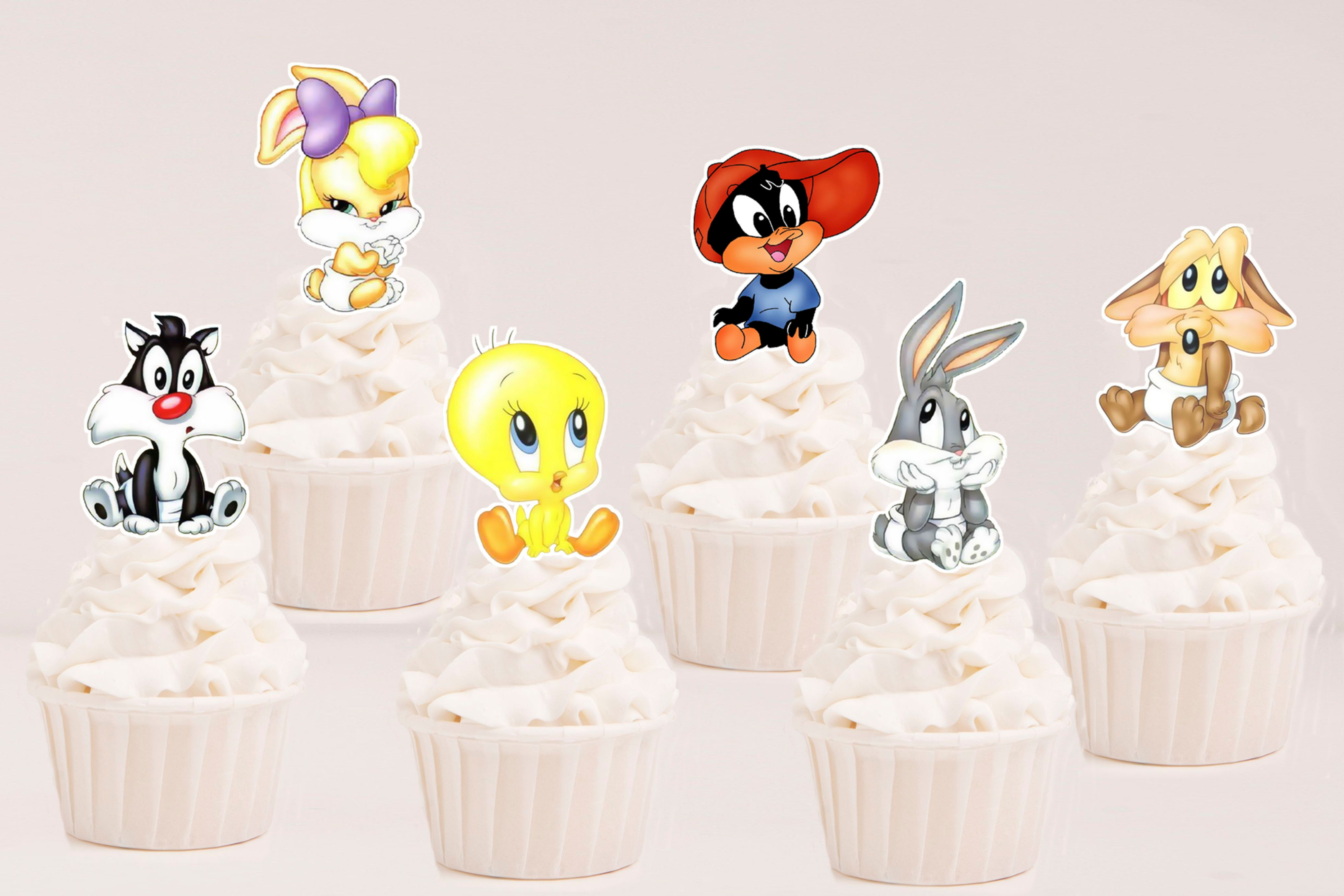 Toppers recortados Baby Looney Tunes aplicados em cupcakes para festa infantil.