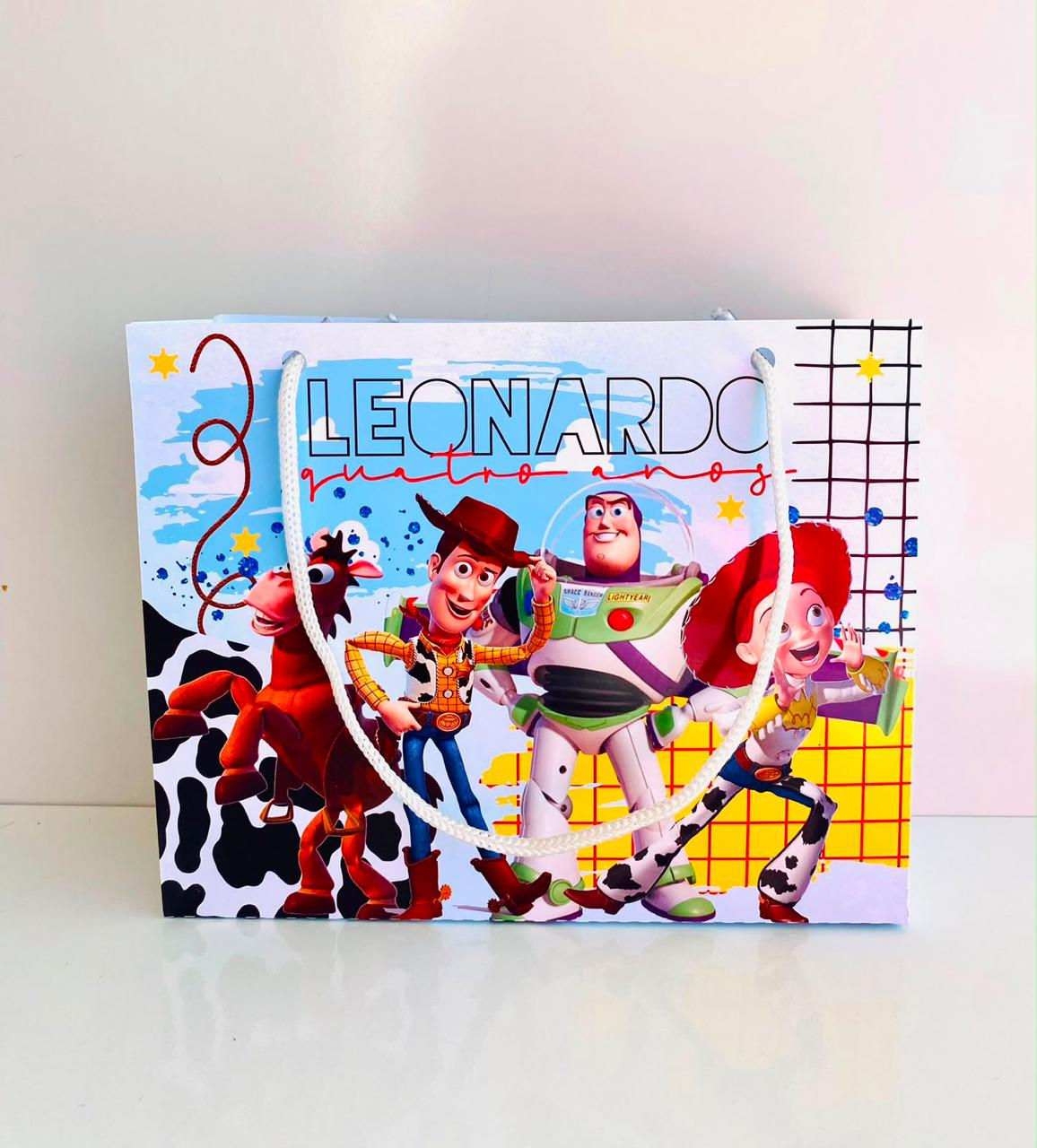 Sacolinha personalizada Toy Story com Woody, Buzz Lightyear, Jessie e Bala no Alvo, nome e idade da criança.