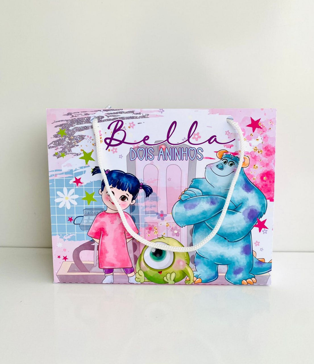 Sacolinha personalizada Monstros S.A. em papel fotográfico, com Boo, Sulley, Mike, nome e idade da criança.