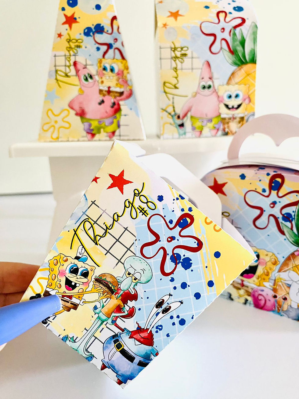 Miniatura: Quatro caixas SpongeBob personalizadas em amarelo e azul-claro, com Patrick, Sandy, Gary, ananás e outras personagens.