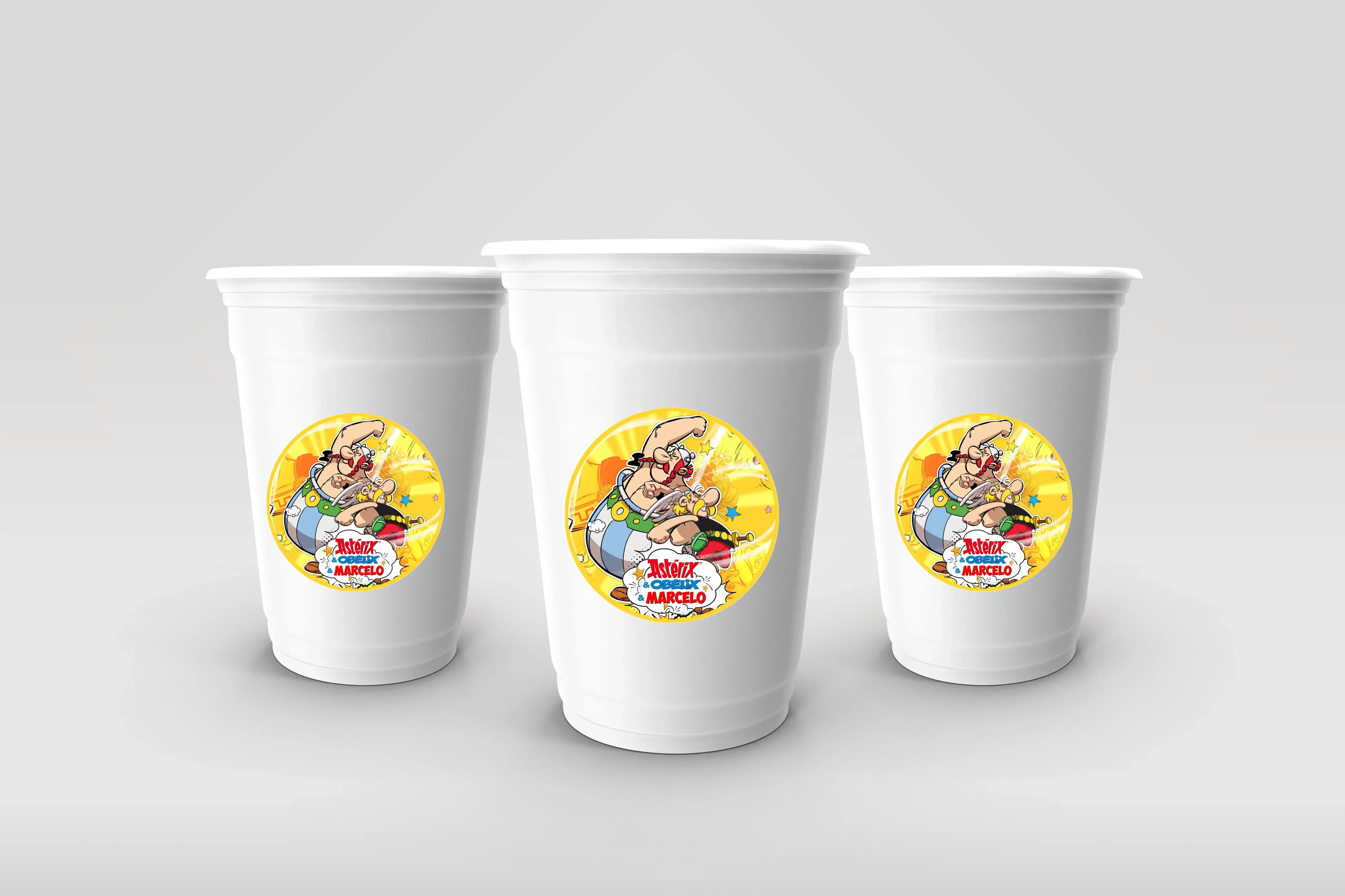 Copos descartáveis com autocolantes personalizados do tema Astérix e Obélix, com nome e idade, ideais para festa infantil.