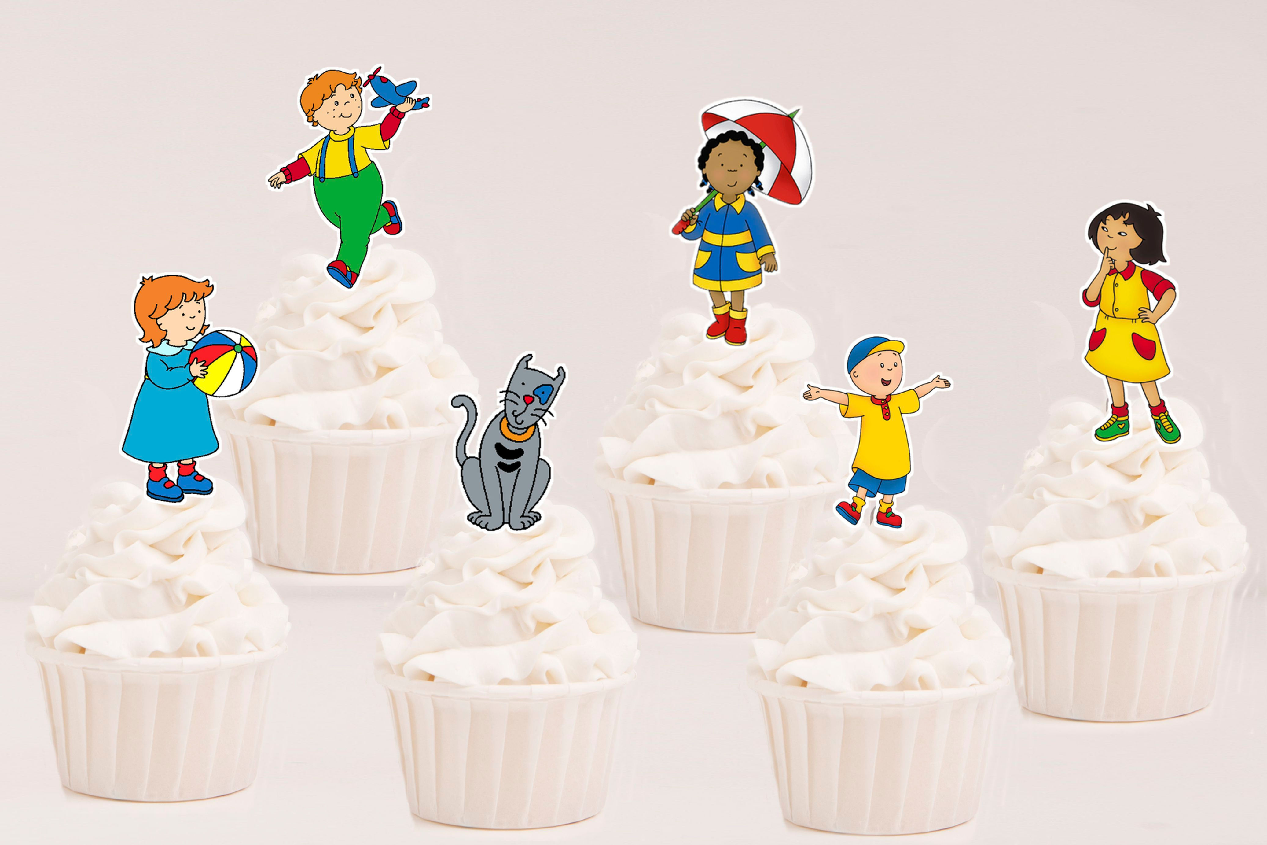 Toppers recortados Ruca com personagens da série aplicados em cupcakes para festa infantil.