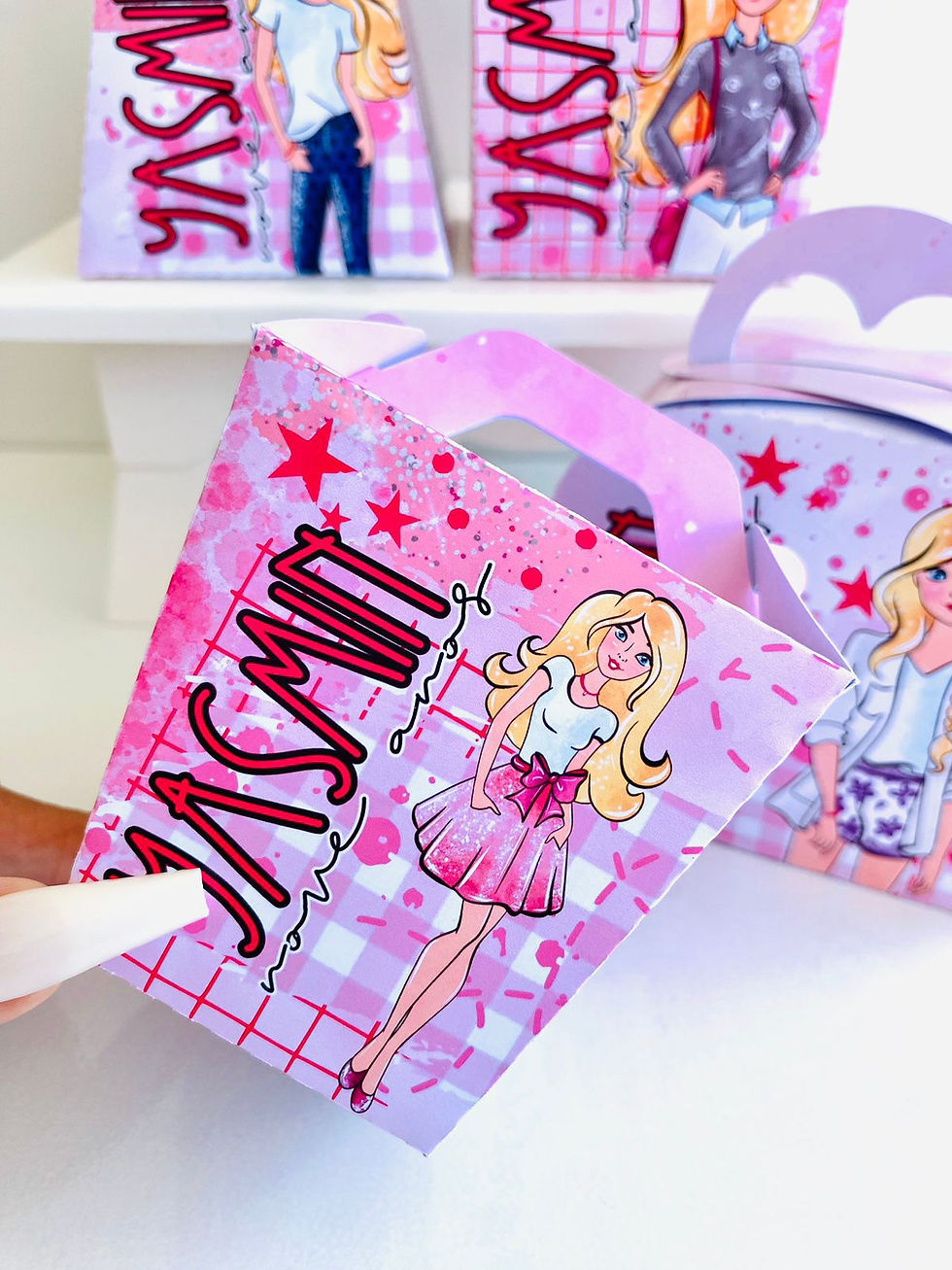 Miniatura: Conjunto de quatro caixas Barbie em rosa e lilás, personalizadas com nome e idade, com estrelas e diferentes roupas da Barbie