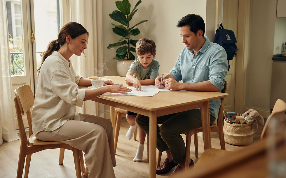Família à mesa a rever orçamento e compras com ambiente simples e acolhedor.