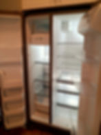 Clean, empty side-by-side refrigerator with open doors