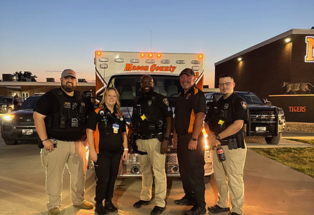 Five emergency responders in front of a Boone County ambulance.
