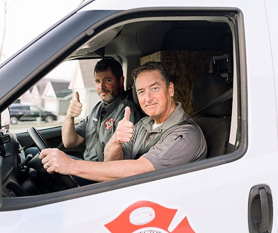 Smoke Detector Services Chris Browder & Tony Johnson giving a thumbs up in their work van after a successful Smoke & CO detector change at a clients house in the St. Louis area