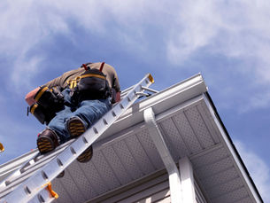 A man climbing onto a roof to perform a roof inspection in Eureka. 