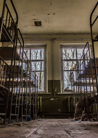 Verlassener Schlafsaal in Tschernobyl mit alten Etagenbetten aus Metall.