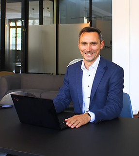 Unternehmensberater für Preismanagement, Marktstrategie und Vertriebsmanagement arbeitet am Laptop in modernem Büro