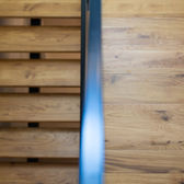 Scale in legno con ringhiera in metallo, vista dettagliata dell'interno della casa.