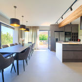 Soggiorno con tavolo e sedie, interno della casa con cucina e vista.