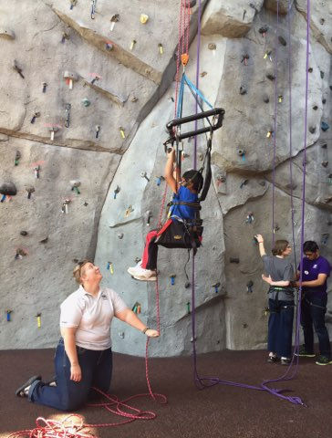 Susie expanding access to rock climbing through her work with a young person using adaptive climbing equipment