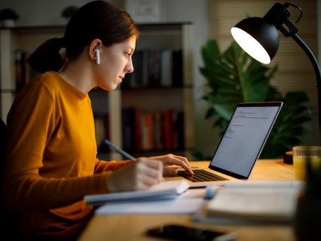 In a cozy home office in Texas, a participant focuses intently on her laptop, diligently taking notes during a 40-hour online clinical supervision training session.
