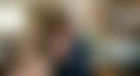 Mujer con tranquilidad señalando un alto y poniendo límites en un entorno de hogar, simbolizando el bienestar emocional y el amor propio al establecer límites sin culpa