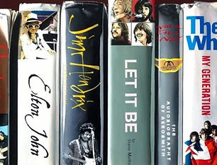 eight Book spines with the names of Queen, Clapton, Elton John, Jimi Hendrix, Let it Be, The Who and Bowie written on them. when clicked this image takes you to the limited edition artowrks by john-Mark Gleadow