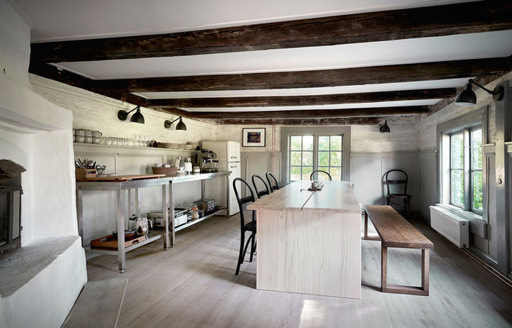 Rustic farmhouse kitchen with exposed beams, large island, and fireplace.