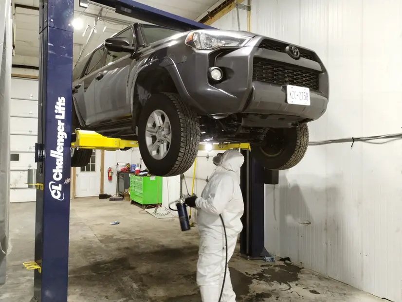 A man in a white suit working on a vehicle