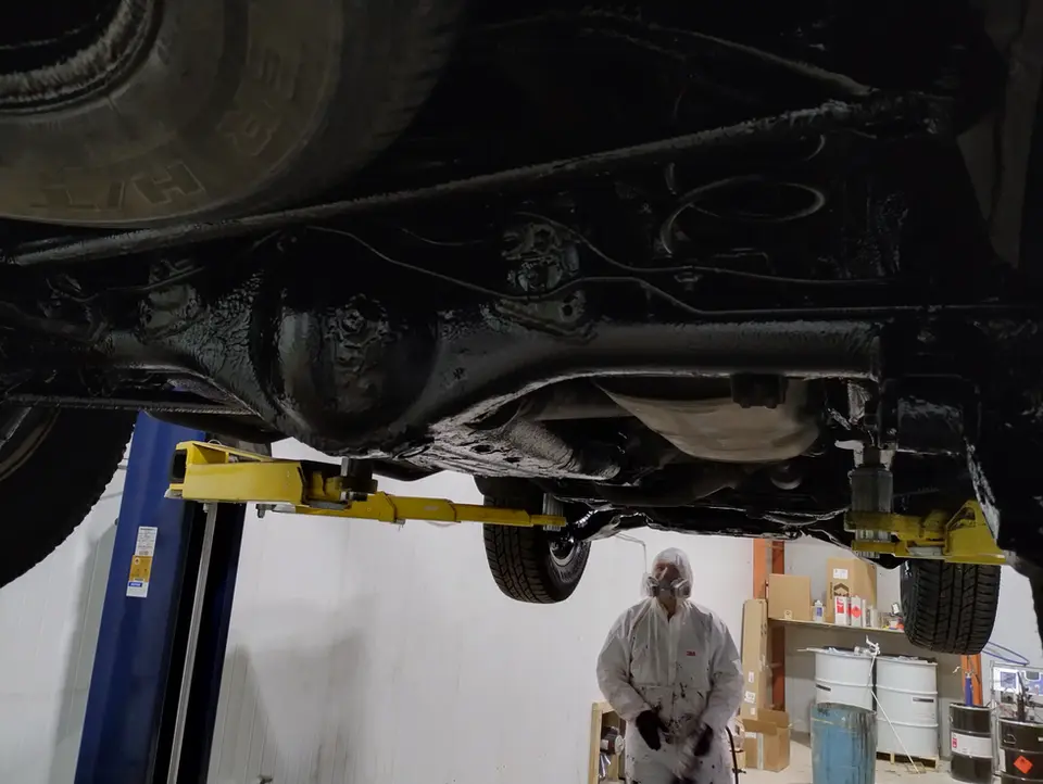 A man working on a vehicle in a garage