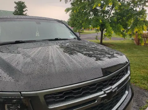 A black truck parked on the side of a road