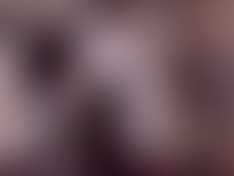 Person writing in a planner on the floor beside a laptop and phone. Magazines and a rug are visible. Casual, productive setting.