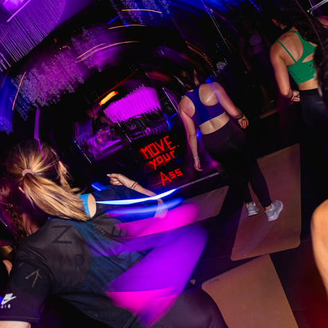 Teilnehmende tanzen und trainieren bei bunten Lichtern im Balboa Club Salzburg – ein Mix aus HIIT, Musik und Party-Atmosphäre beim GROOVE Clubworkout.