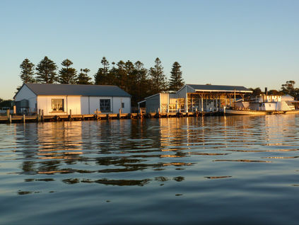 Fleurieu Distillery’s Goolwa Wharf setting, with the historic sheds and a paddle steamer seen across the water.
