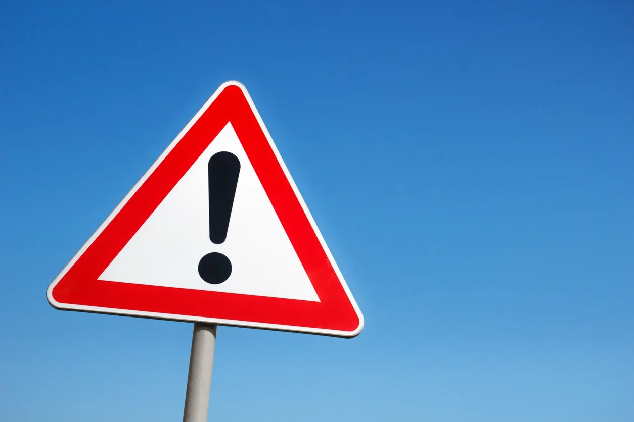 danger sign against blue sky