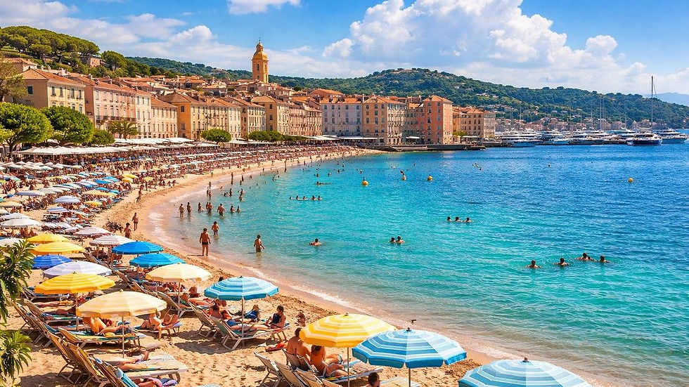Praia na EUROPA lotada em cidade costeira, guarda-sóis coloridos e banhistas no mar azul, com prédios e marina ao fundo.