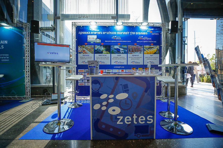 דוכן Zetes עם מסכים ועמדות הדגמה לפתרונות אוטומציה.