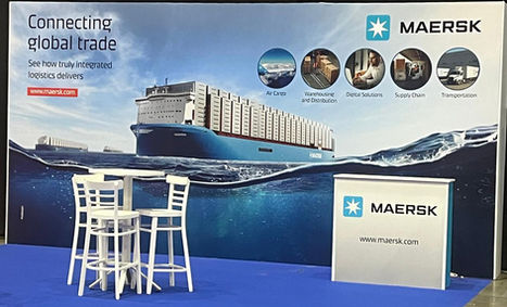 דוכן תערוכה של MAERSK עם גרפיקה של ספינת מטען ומיתוג לוגיסטי.