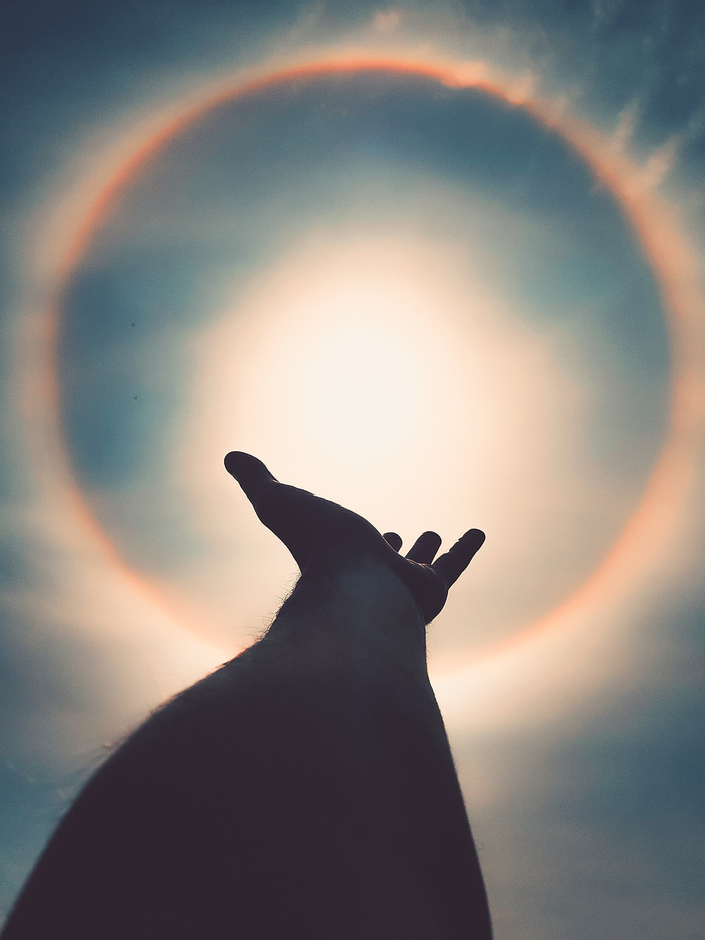 Hand extending towards sun
