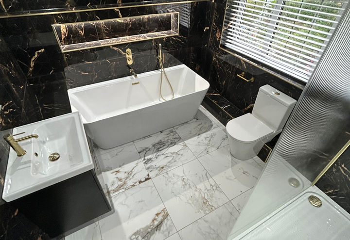 Marble bathroom in Warsash, Southampton. Featuring marble tiles, freestanding bath and vanity unit