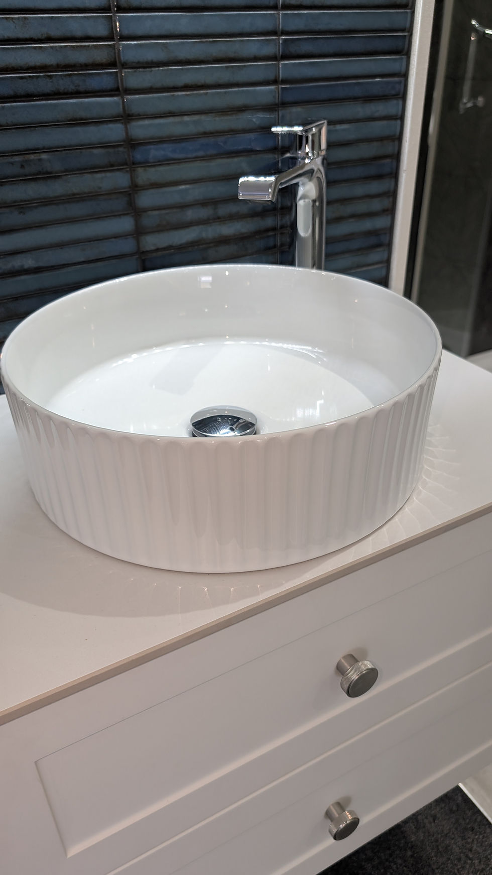 Eye-level view of a vibrant bathroom wall with fluted basin