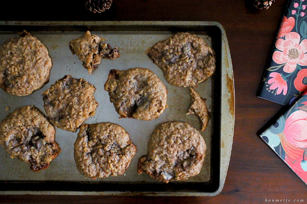 Caramel apple snickerdoodle cookies, half eaten, on a baking sheet with notebooks in the background