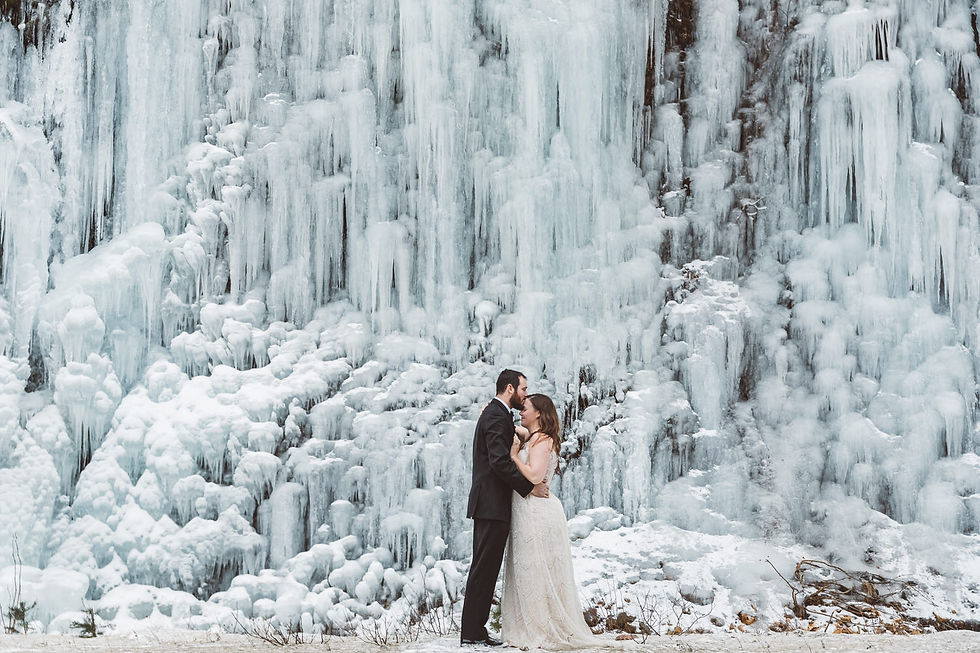 bride and groom at ice wall during winter wedding