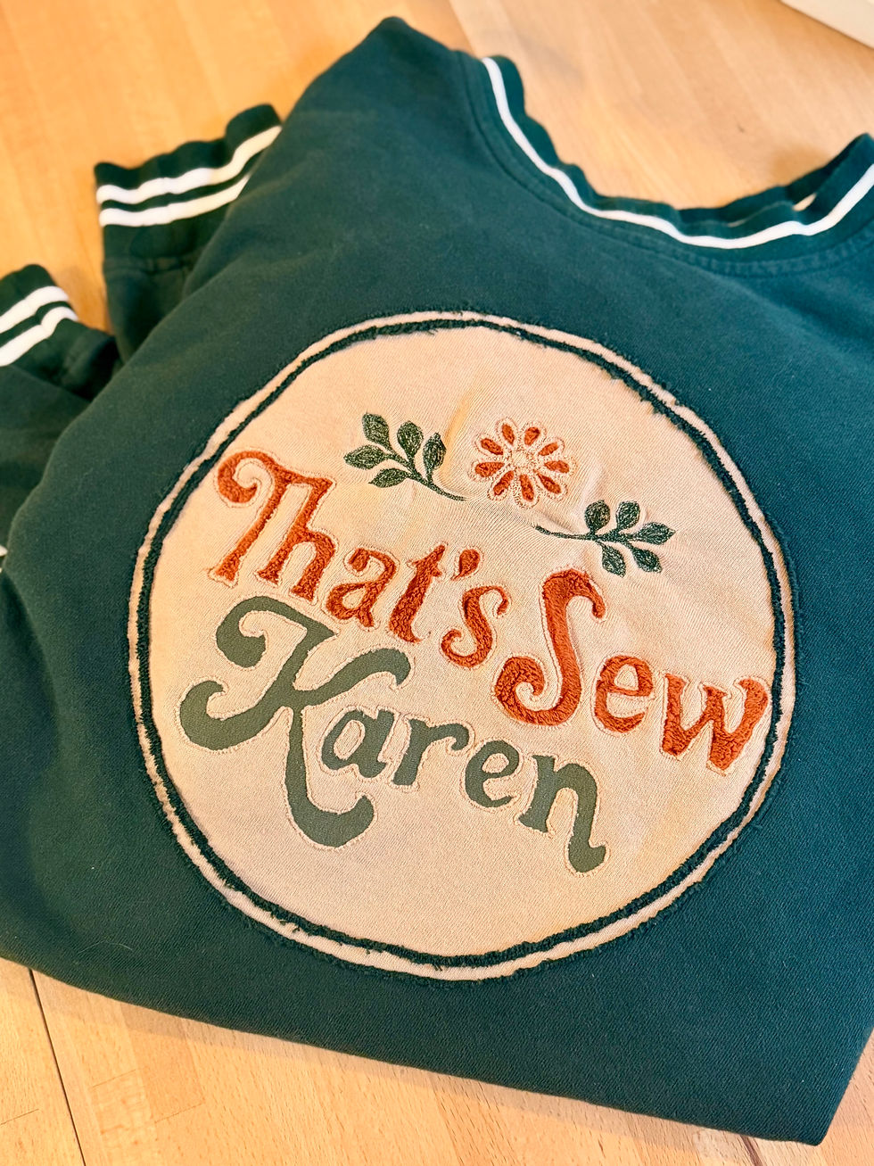 My example of reverse applique: The letters and circle are all reverse applique. the flower is reverse applique and the leaves are embroidery.