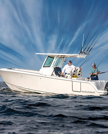 Sailfish boat floating in open water with two fisherman at the back of the boat fishing.