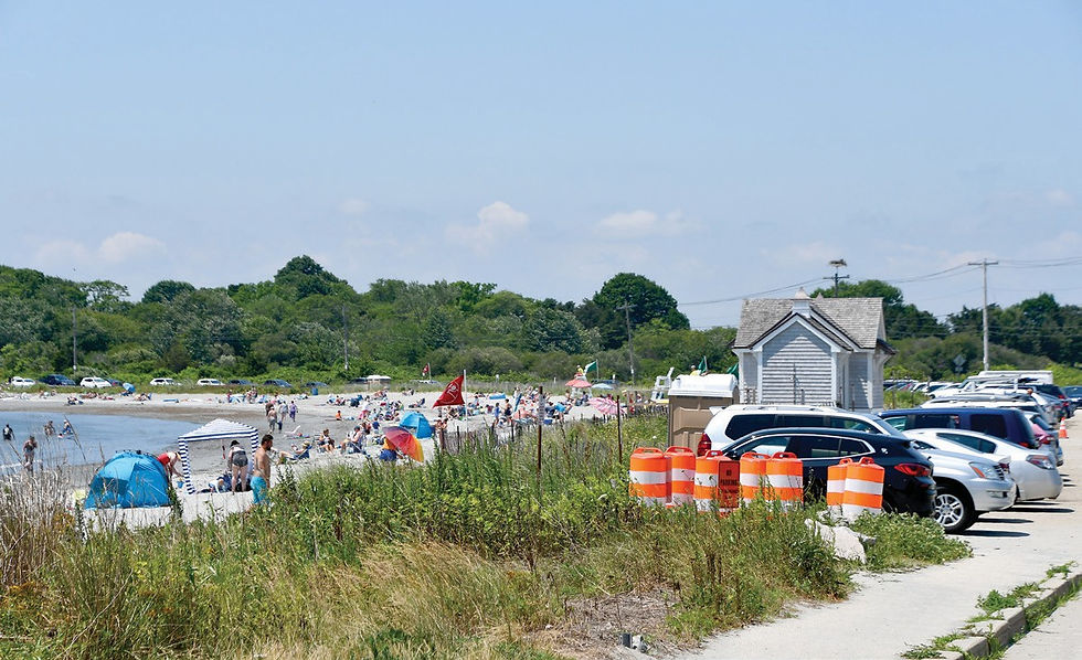 Mackerel Cove Beach in Jamestown, Rhode Island with summer visitors and coastal parking area