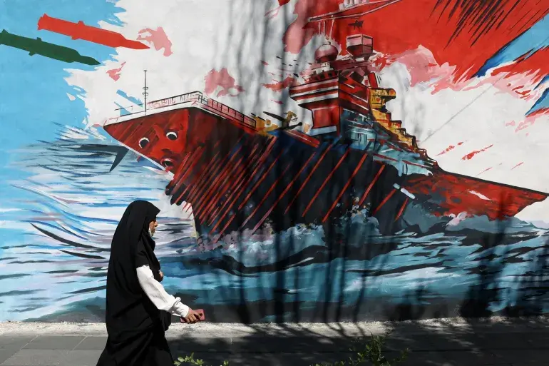 A mural in Tehran depicts a US aircraft carrier under attack on May 18 [File: Majid Asgaripour/WANA via Reuters]