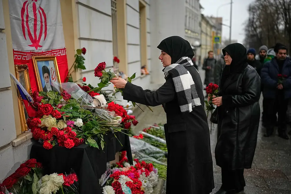 Iranian students who study in Russia lay flowers by a portrait of the late Ayatollah Ali Khamenei outside the Iranian Embassy in Moscow on March 2. (Alexander Zemlianichenko/AP)