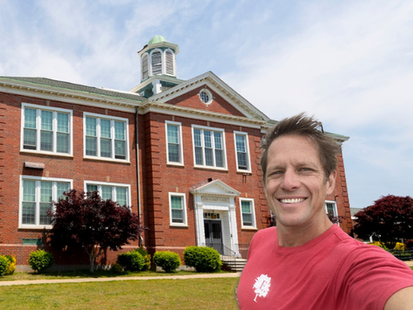 Chris Lambton in front of Ezra Baker School