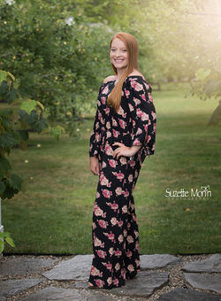 high school senior posing in a apple orchard for her pictures