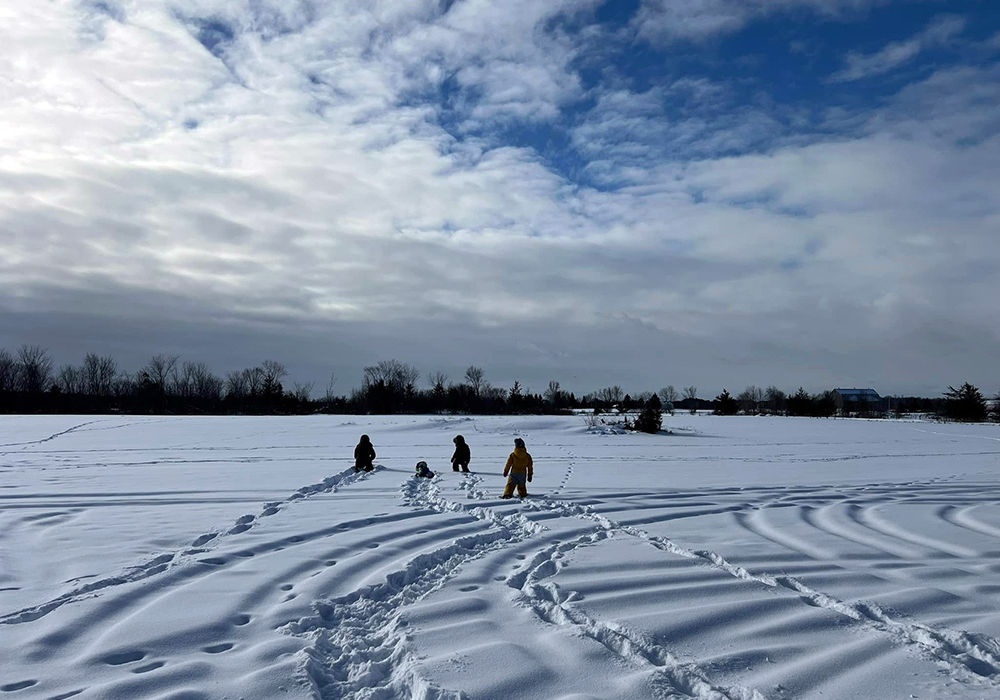 Children walking in a field of snow